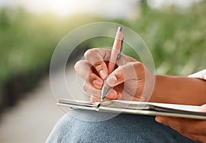 Laying out a new plan. Closeup shot of an unrecognisable man writing notes while working on a farm.