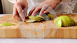 Laying out slices of a pear on a wooden board. Video recipes.