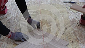 Laying parquet in an apartment during renovation. Herringbone parquet video 4k. Worker installing wood parquet