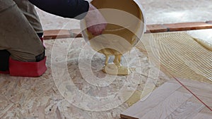 Laying parquet in an apartment during renovation. Herringbone parquet video 4k. Worker installing wood parquet