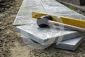 Laying a paving stone or brick. Gray concrete slabs in house courtyard on sand foundation base