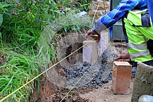 Laying paving stones. The foreman arranges concrete palisades. Paving work in the garden.