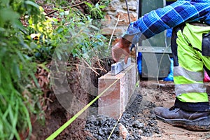 Laying paving stones. The foreman arranges concrete palisades. Paving work in the garden.