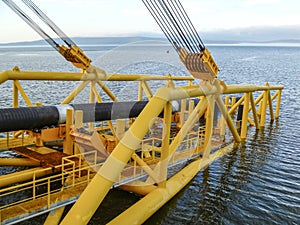 Laying of pipes with pipe-laying barge crane near the shore. Des