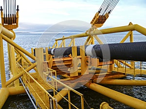 Laying of pipes with pipe-laying barge crane near the shore. Descent of the pipeline to a bottom exhausting with the pipelaying ba