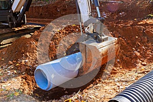 Laying pipes to feed rainwater into water main collector at a construction site