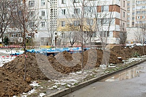 Laying sewer PVC pipes. Prepared trenches for laying sewer pipes, fenced with safety tape.