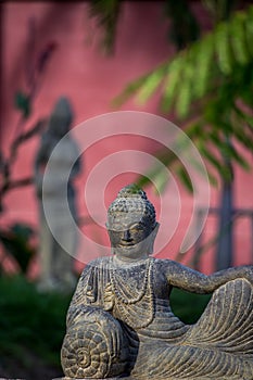 Laying stone Buddha statue in garden