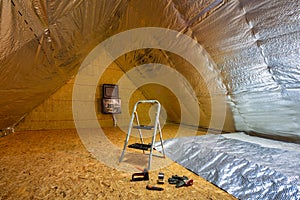 Laying the thermal insulation foil on the insulated attic in the house