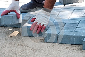 Laying tiles on the sand preparatory work to repair the sidewalk