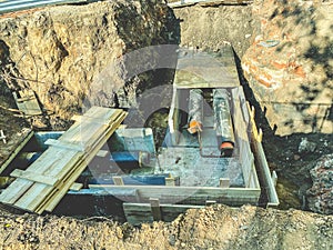 Laying of underground communications for residential buildings. black plumbing pipes are buried underground on a wooden foundation