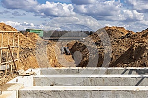 Laying of underground pipes in concrete chamber. Installation of water main at the construction site. Construction of stormwater