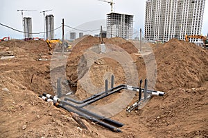 Laying water pipes with insulation of the central heating systems in the ground. Installing concrete sewer wells and underground