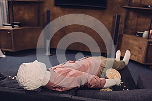 layman doll in casual clothes lying on sofa
