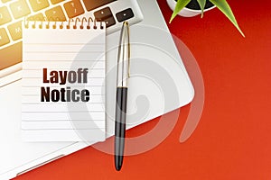 LAYOFF NOTICE text with notepad, laptop, fountain pen and decorative plant on red background