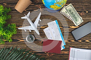 Layout of airplane travel accessories on a wooden background. Top view