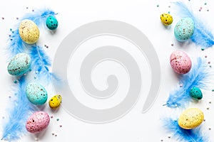 Layout of colorful Easter eggs and birds feather, top view