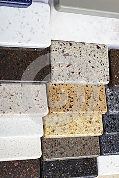 Layout: colorful specimens of granite, marble and quartz natural stone slabs.Close-up of stone kitchen countertops samples