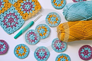Layout of crochet patterns, hook and two skeins of thread on white background