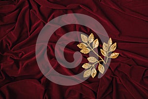 Layout of gold and shiny branch with leaves on a red silk or saten background. Minimal concept with copy space photo