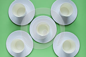 The layout on a green background from paper disposable plates. Caring for the environment. Recycling and sorting of garbage.