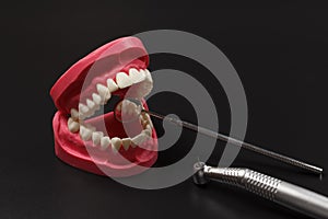 Layout of the human jaw with metal mirror and head of high-speed dental handpiece.
