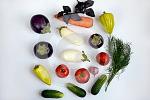 Layout of tomatoes, peppers, eggplants, carrots, cucumbers and greens on a white background