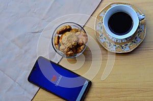 lazada apps on smartphone, with coffe and cake
