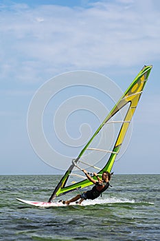 Lazurne Ukraine 09.09.2018 Side view of young man surfing the wind on summer day