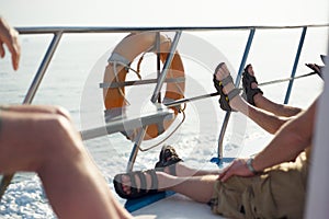 Lazy boat trip with sandals on railing