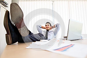 Lazy businessman put his legs on the desk