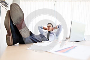 Lazy businessman put his legs on the desk