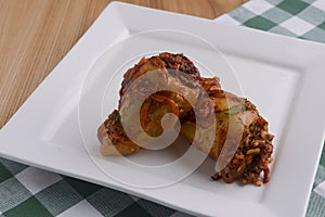 Lazy cabbage rolls. Stuffed cabbage leaves with minced meat and rice in tomato sauce with onion on white plate.l