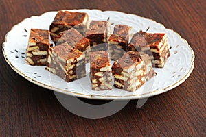 Lazy cake or mosaic cake . Homemade no bake chocolate biscuit cake on a wooden table photo