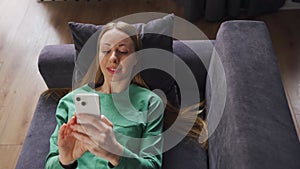 Lazy happy customer woman browsing social media, shopping in app, playing mobile game, news reading