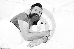 Lazy hipster relax in bedroom. good night and sweet dreams. bearded man teddy bear in bed. plush toy concept. happy