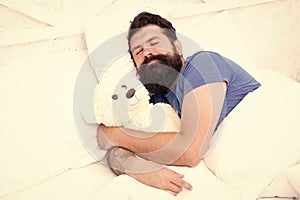 Lazy hipster relax in bedroom. good night and sweet dreams. bearded man teddy bear in bed. plush toy concept. happy