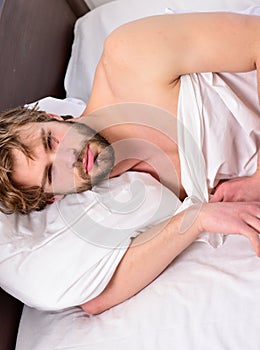 Lazy man happy waking up in the bed rising hands in the morning with fresh feeling relaxed. Feet of man sleeping in