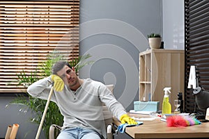 Lazy man procrastinating while cleaning