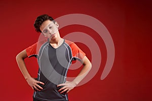 Lazy mode. A teenage boy is engaged in fitness, he closed his eyes while doing exercise. Isolated on red background