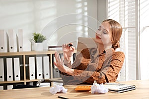 Lazy office worker doing manicure at desk