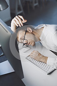 Lazy office worker sleeping at his desk