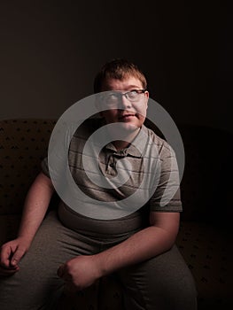 Lazy overweight male sitting on couch and watching something