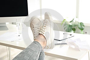 Lazy overweight worker with feet on desk in office