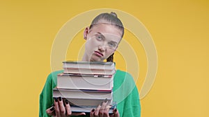 Lazy schoolgirl student is dissatisfied with amount of books homework on yellow
