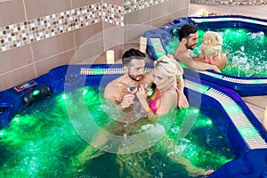 Lazy weekend for two - Couple relaxing in jacuzzi at health spa stock photo