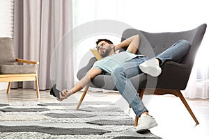 Lazy man playing video game while lying on sofa at home photo