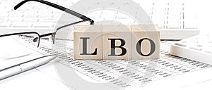 LBO written on wooden cube with keyboard , calculator, chart,glasses.Business concept