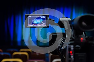 The LCD display on the camcorder. Shooting theatrical performances. The TV camera. Colorful chairs in the auditorium