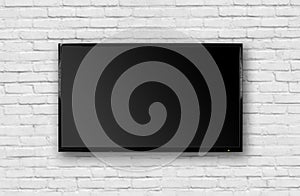 LCD TV with a thin black frame hanging on a white brick wall. Blank black screen. Isolated on white background